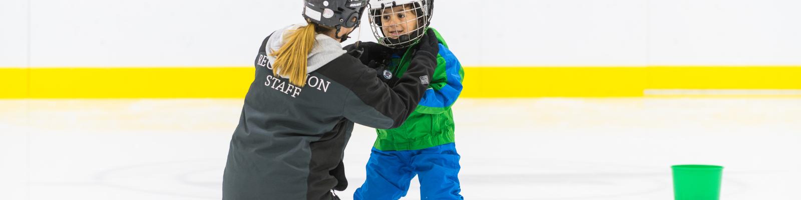Instructor and child on indoor ice rink