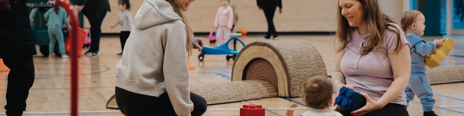 Women and child playing in gymnasium