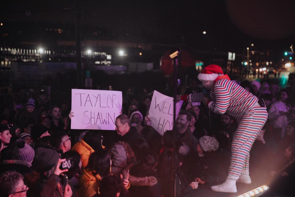 crowd holding up signs at holiday train performance
