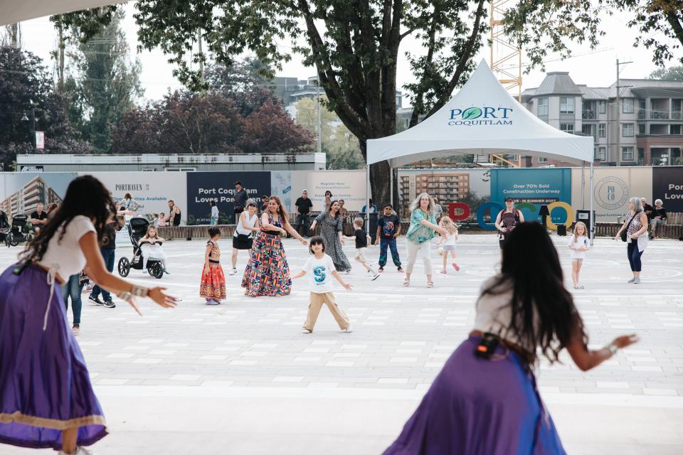 dancers on stage at Leigh Square with people following steps in background