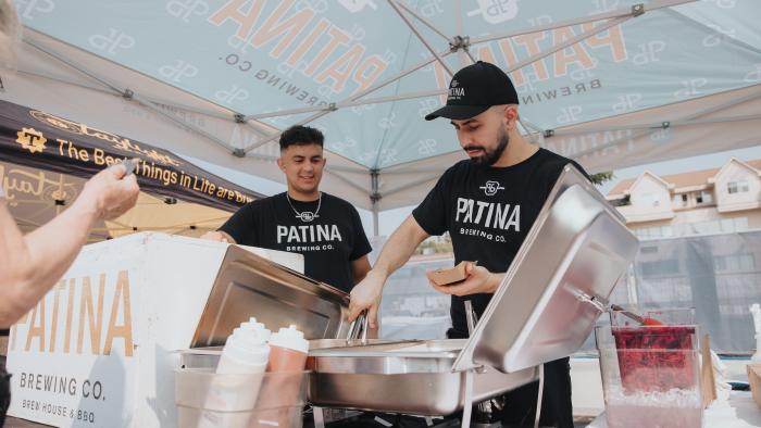 two people serving drinks from a cooler