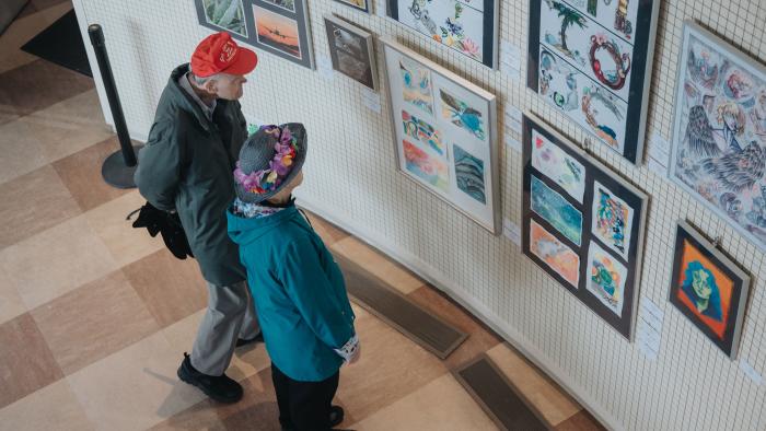 two people in Michael Wright Art Gallery, looking at artwork on display