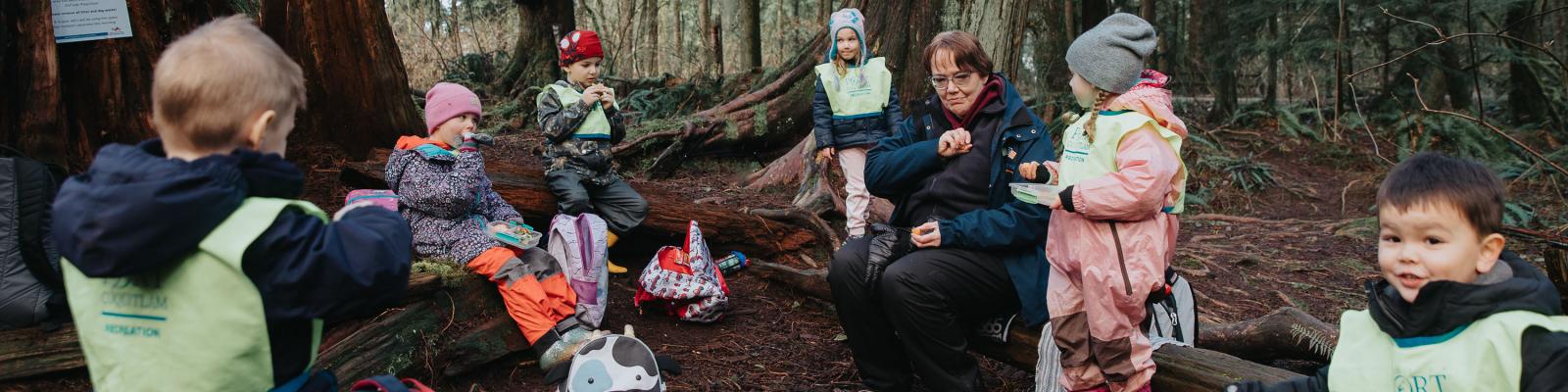 Kids participating in recreation program sitting outside in the forest