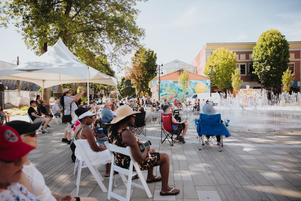 people in Leigh Square on chairs in sunshine